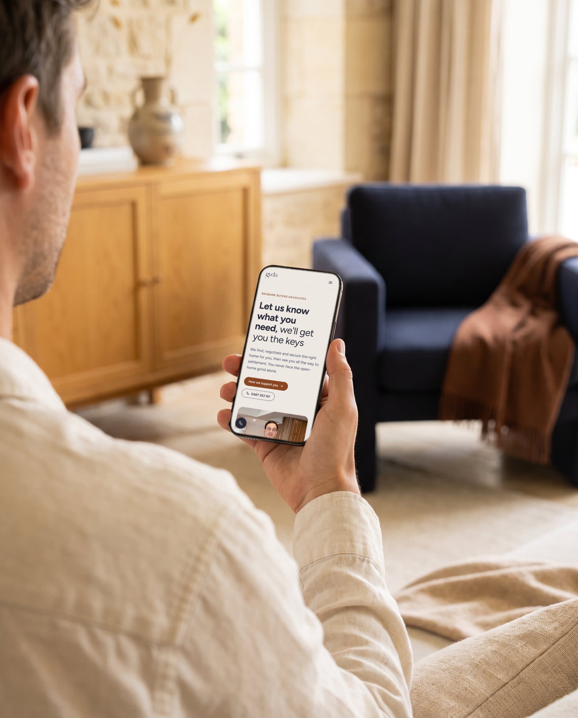 Someone reading the gyda home page on a phone in a living room